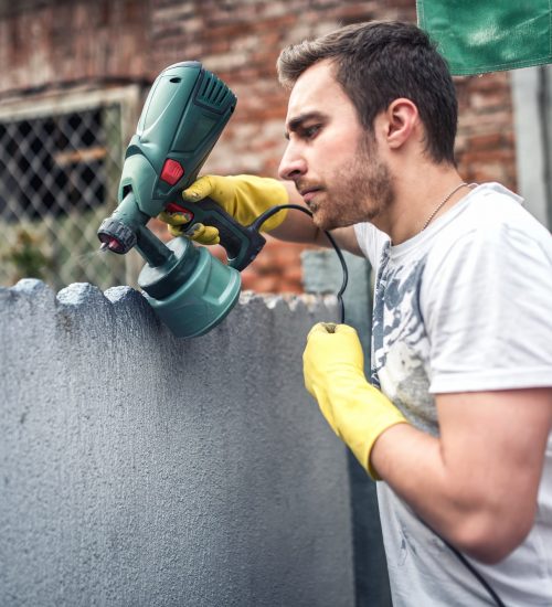 Professional construction worker painting walls at house renovation